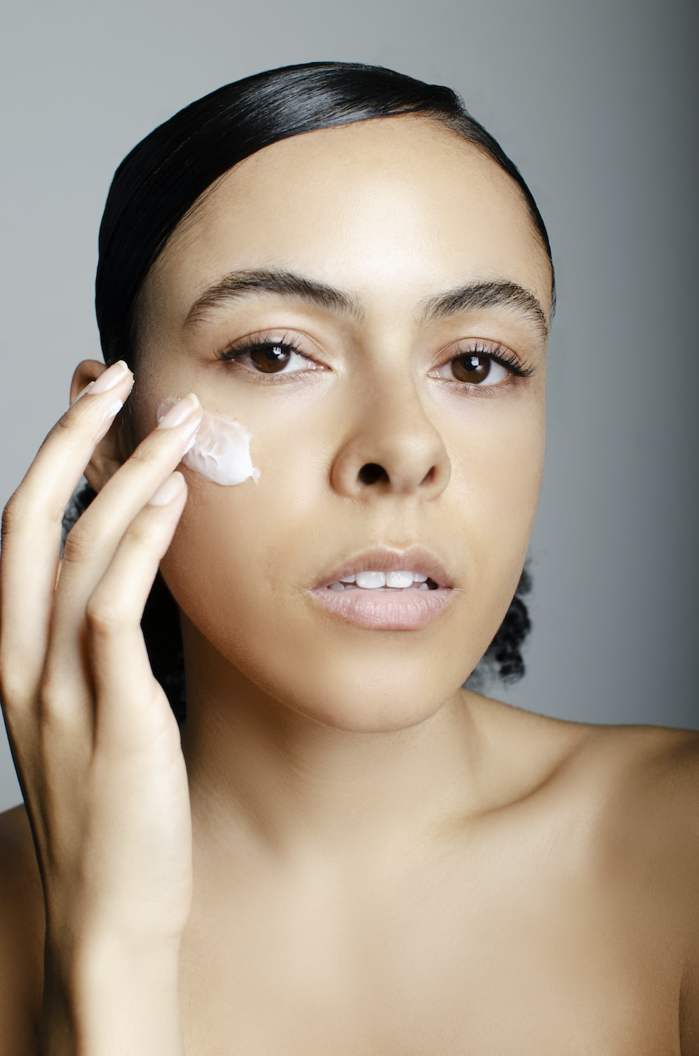 a woman putting on the face cream