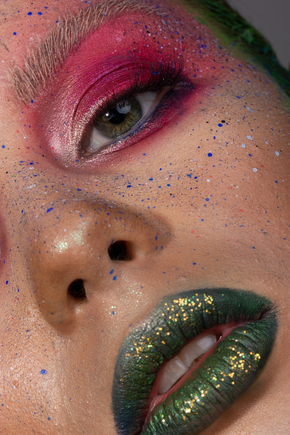 a woman with green lips showing a shade of green with golden glitter