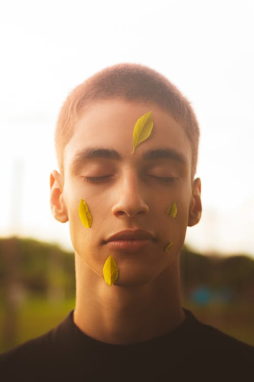 a man with five leaves stuck to his face