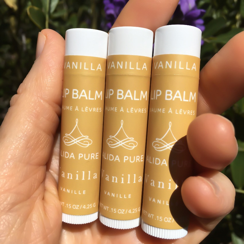 a person holding vanilla-flavored lip balm tubes in their hand
