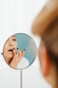 a woman applying lip balm in the mirror