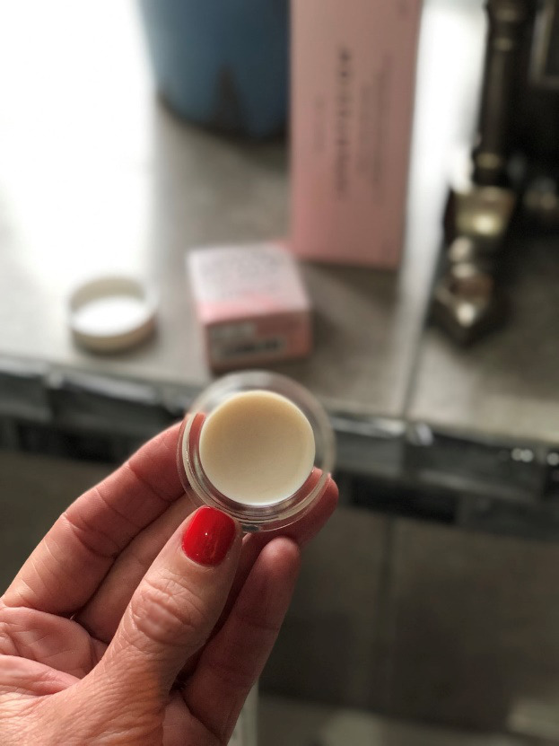 a person holding a lip balm container