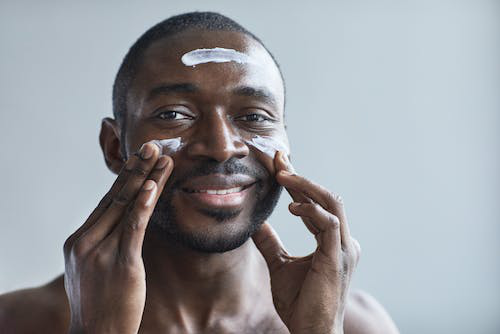 a man applying moisturizer on his face