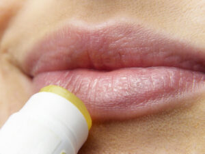 a person applying lip balm on their lips