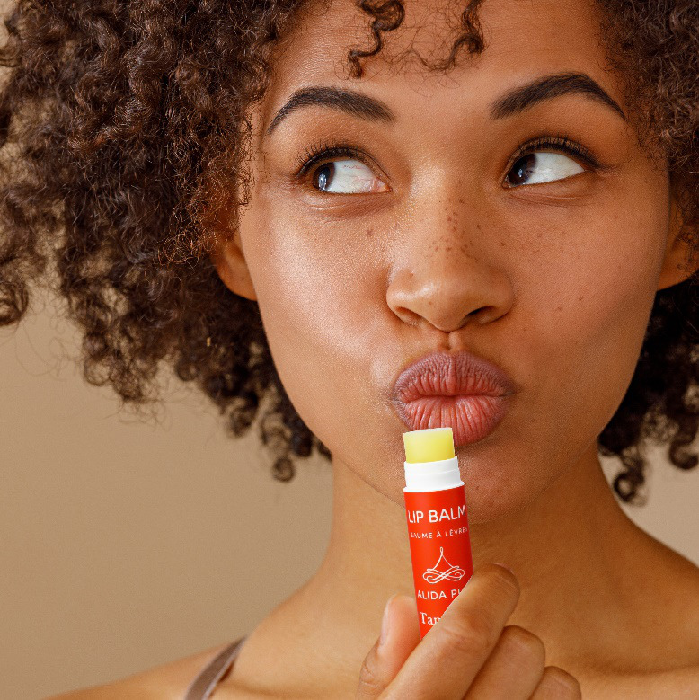 A woman is holding a lip balm.